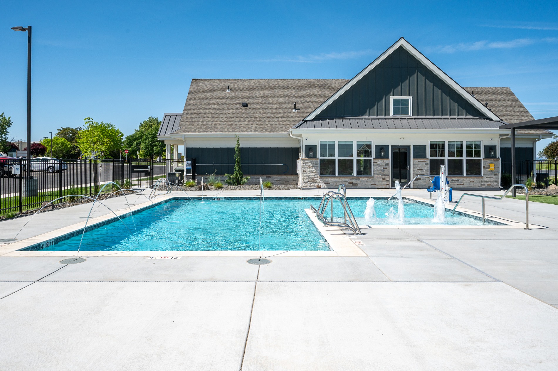 A clubhouse with a pool in front.